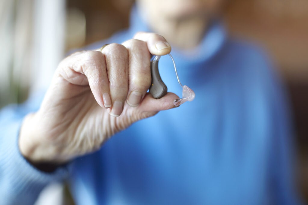 senior woman holding hearing aid close up 2023 11 27 05 13 13 utc scaled